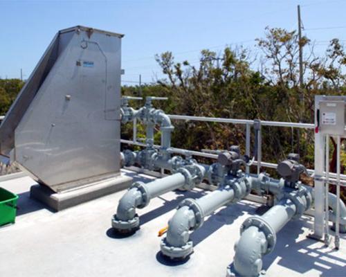 Pipes, controls, and metal structure on top of concrete water container